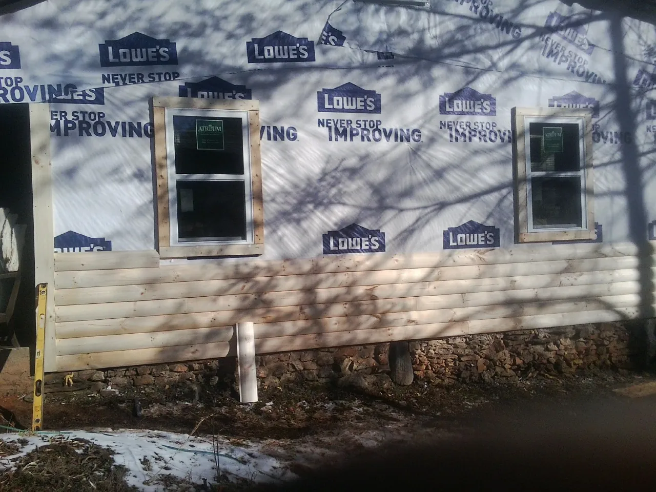 House wrap and new log siding going up on an exterior wall in Washington Crossing