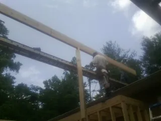 Carpenter setting a ridge beam over a new addition frame — Ice Dam Removal by Roofing Brothers in Washington Crossing