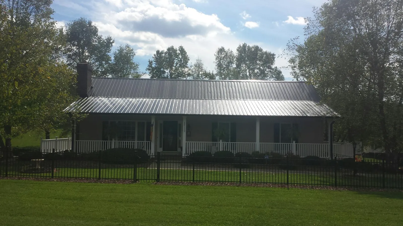 Gray metal roof on a brick ranch with a full width front porch — Gutter Guard Installation work by our crew in Washington Crossing