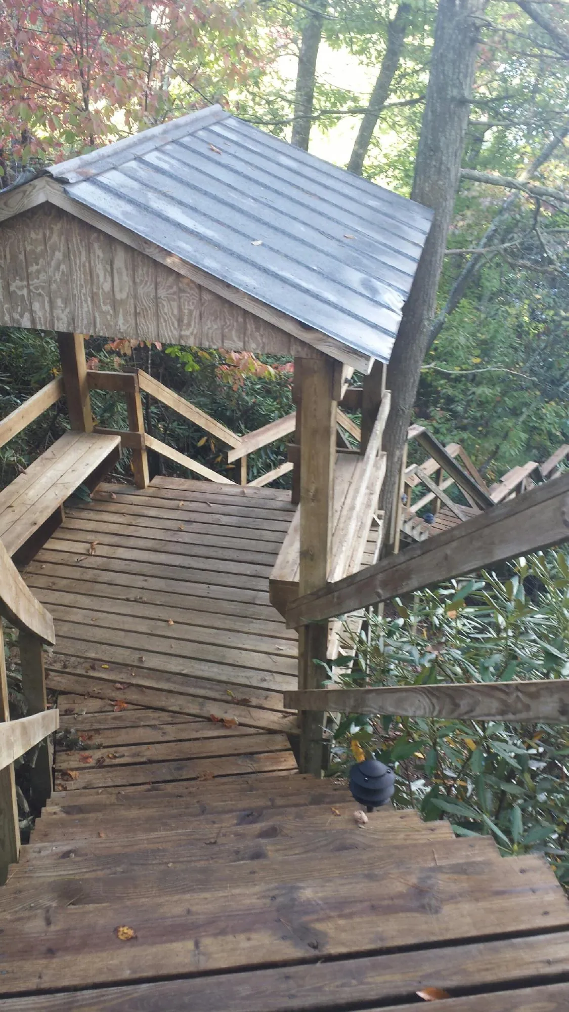 Metal roofed shelter over wooden steps on a wooded walkway — Skylight Repair & Installation work by our crew in Washington Crossing